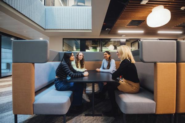 A group of staff and students talking at a table